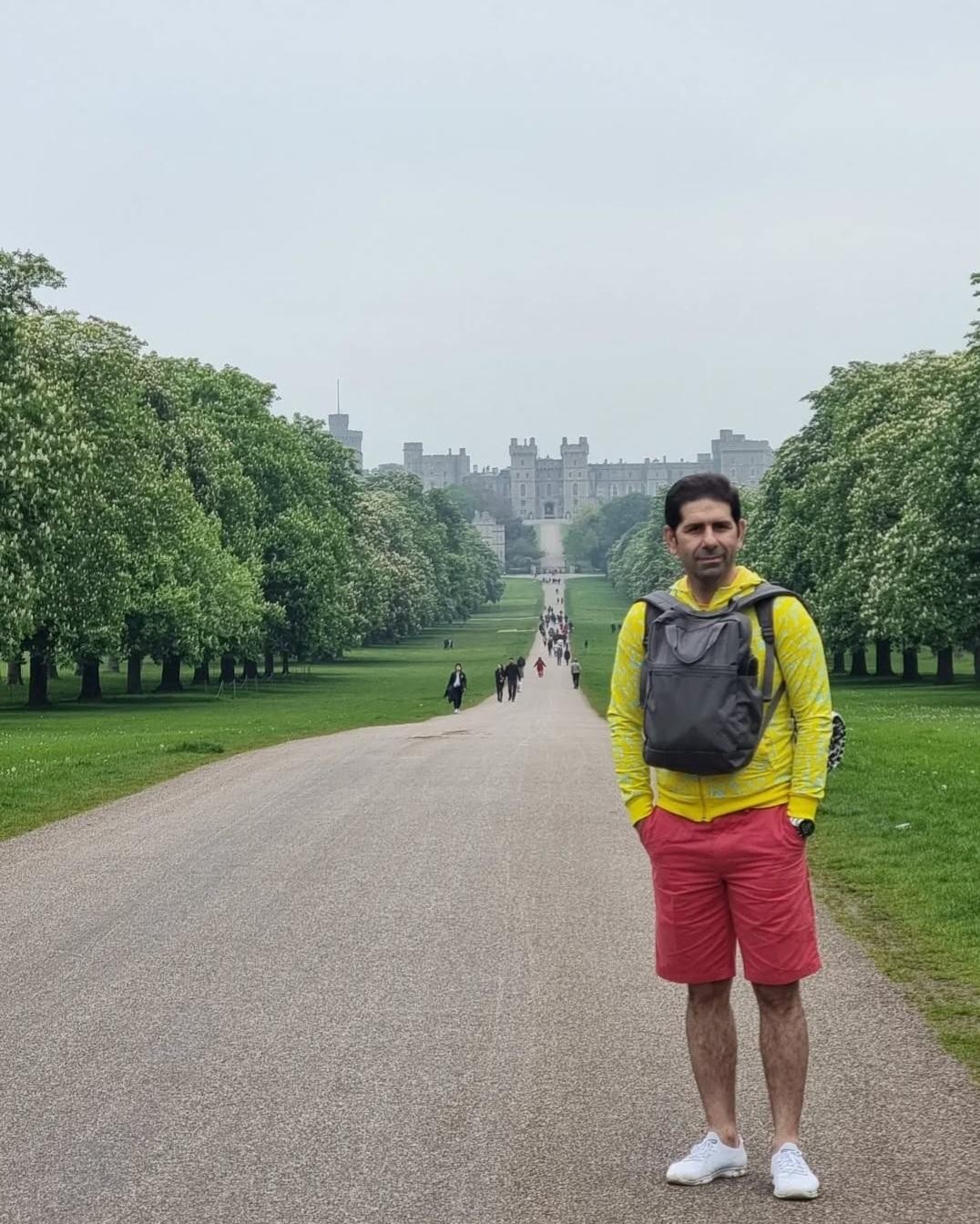 Man stood at the top of a long path that leads to a castle