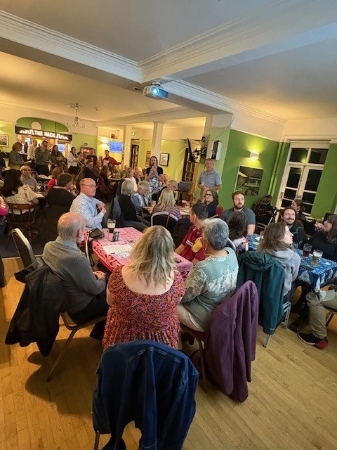 Guest sat around round tables at a charity fundraising event