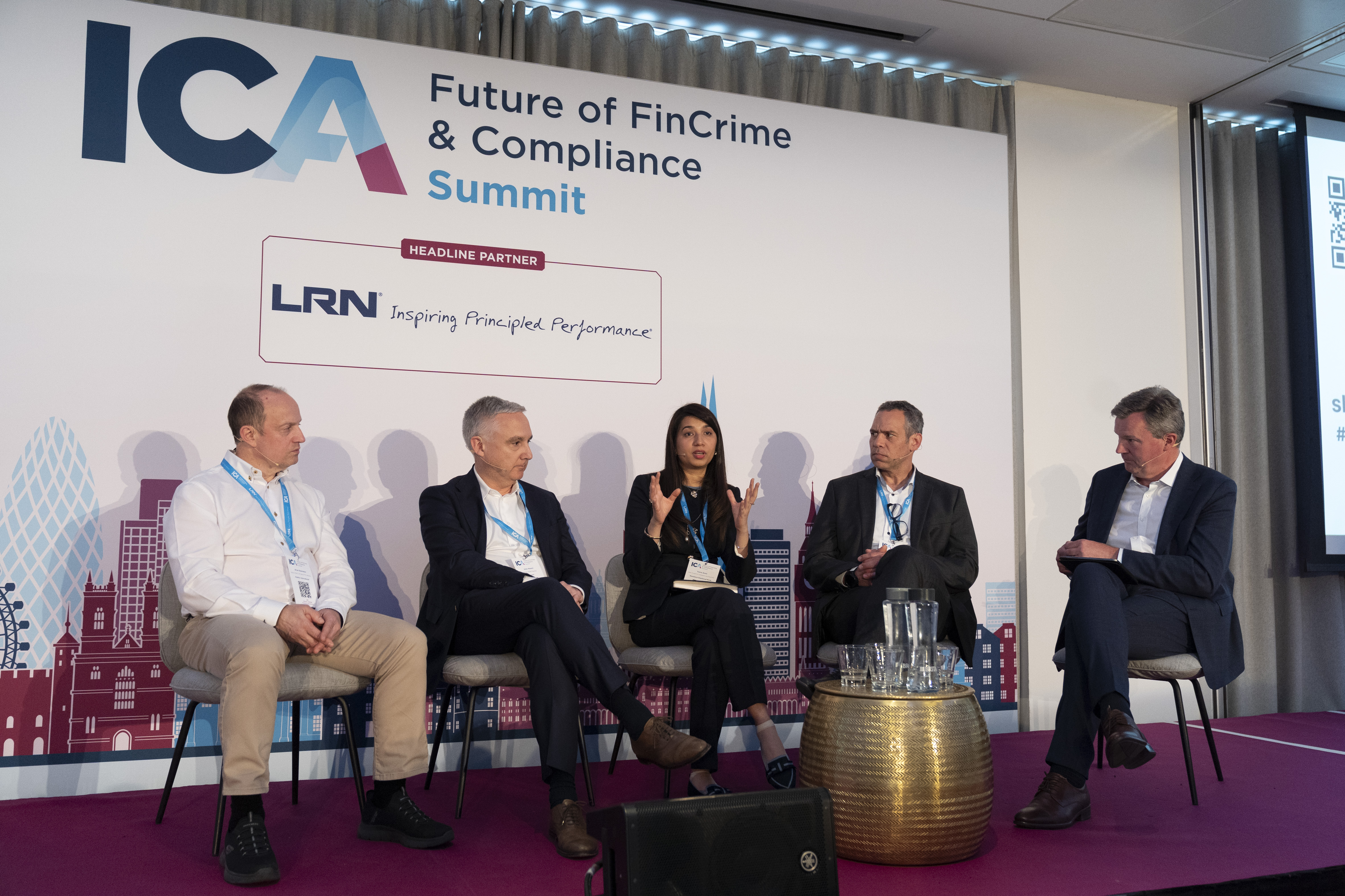 People sat on chairs, on a stage in a panel discussion